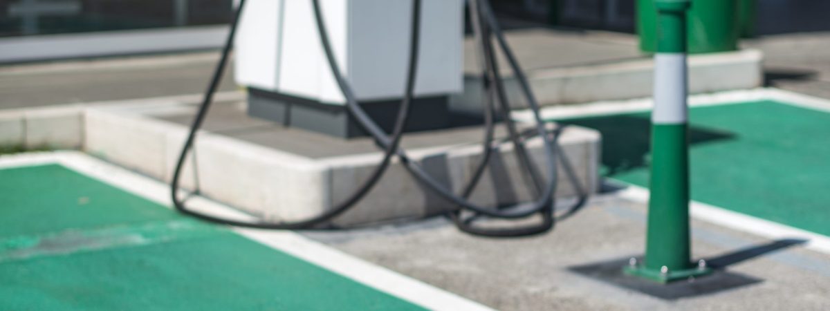 Electric charge station. Electric plug for charging cars. Car charging symbol painted on asphalt. Ecology fuell concept.